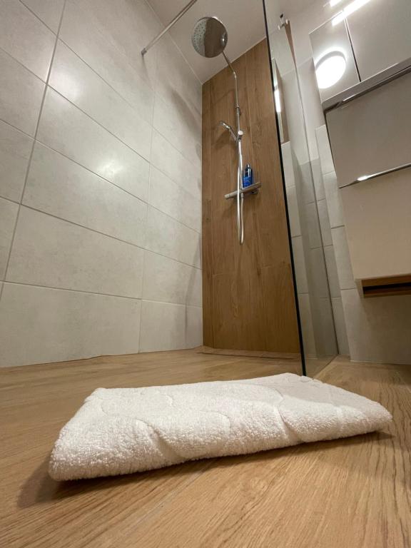 a bathroom with a shower with a white rug at Gdynia Riviera Hills in Gdynia