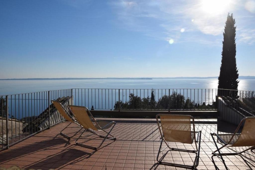 two chairs sitting on a patio overlooking the ocean at Ferienhaus in Garda mit Garten, Grill und Terrasse in Garda