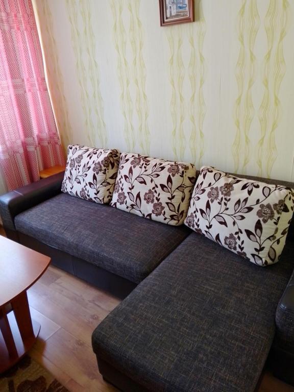 un sofá con 2 almohadas en la sala de estar en Namas en Klaipėda