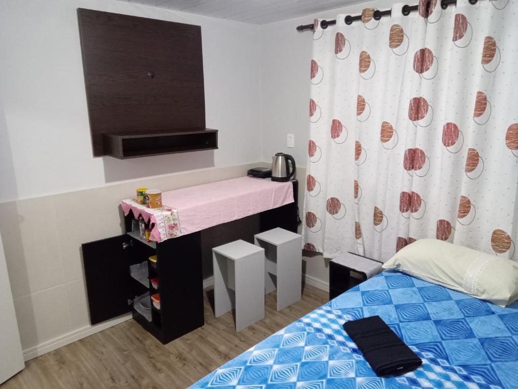 Dormitorio pequeño con cama y lavamanos en POUSADA ALTERNATIVA MANU LAGES Quarto wc comp, en Lages