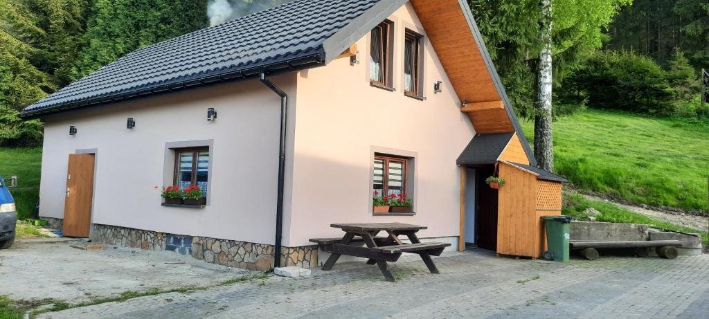 a building with a picnic table in front of it at Domek przy Złotym Groniu in Istebna
