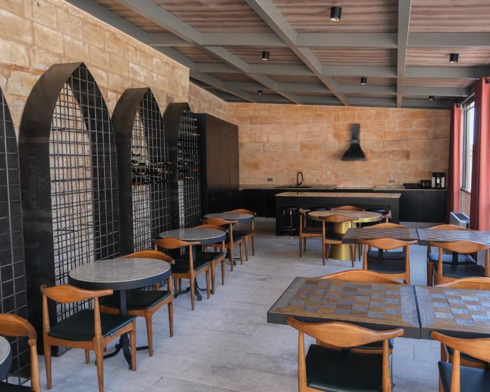restauracja z drewnianymi stołami i krzesłami oraz bar w obiekcie Mirsoum Han w mieście Mardin