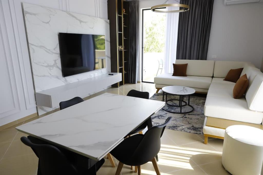 uma sala de estar com uma mesa branca e cadeiras em Cozy Apartments em Tirana