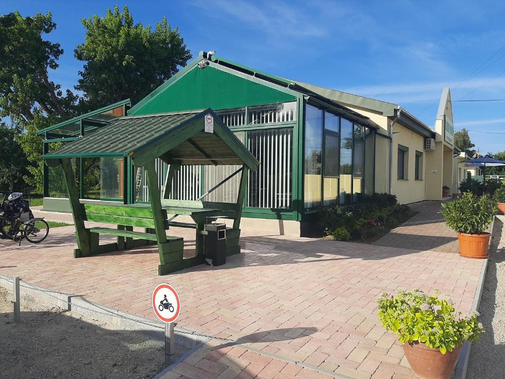 a small green building with a green roof at Szárszó Apartmanok in Balatonszárszó