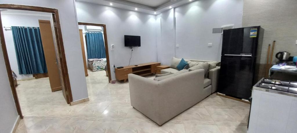 a living room with a couch and a tv and a kitchen at Ikea flat 10 in Hurghada