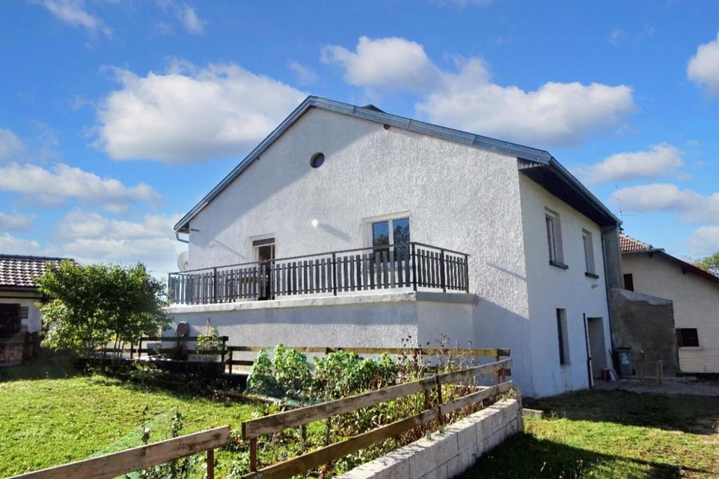 ein weißes Haus mit einem Balkon und einem Zaun in der Unterkunft Maison de 2 chambres avec jardin clos et wifi a Hauts de Bienne in Lézat