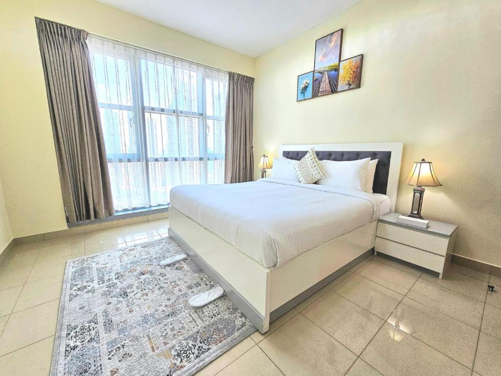 - une chambre avec un lit et une grande fenêtre dans l'établissement Trinity Holiday Homes - Standpoint Tower Downtown, à Dubaï
