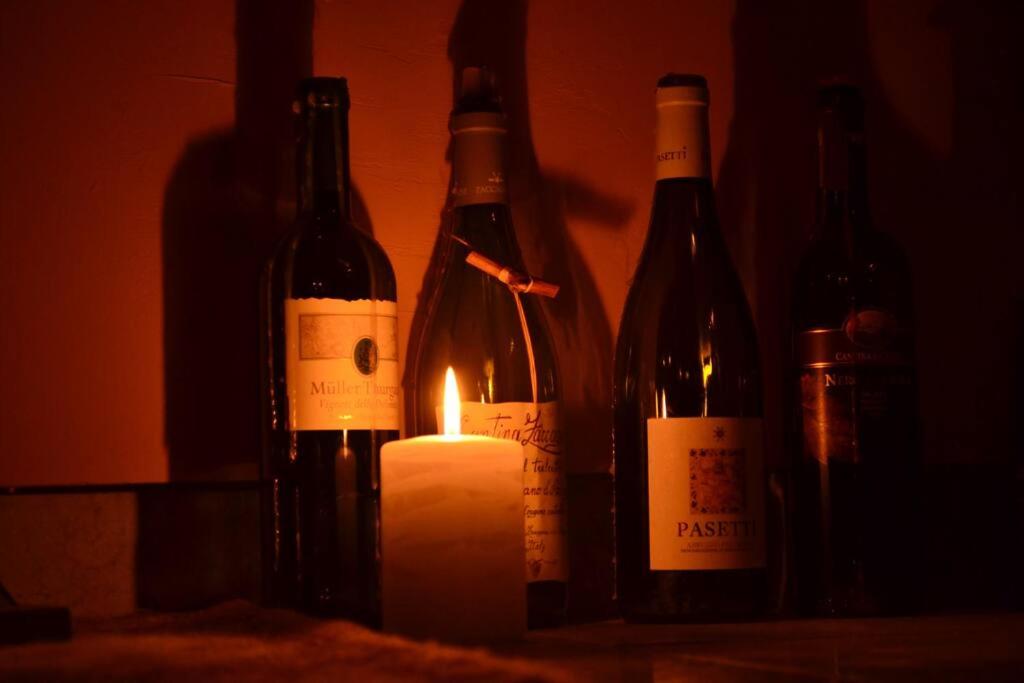 um grupo de garrafas de vinho e uma vela em Mōnø em Popoli
