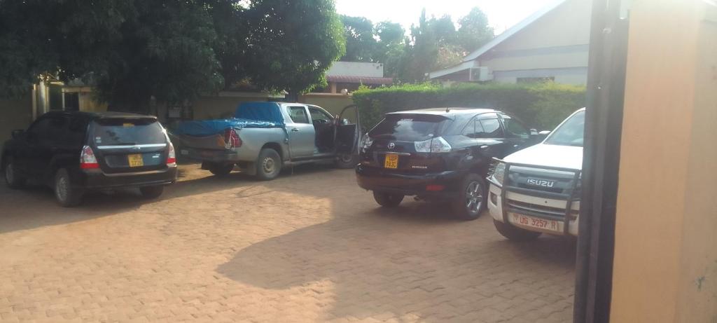 un grupo de autos estacionados en un estacionamiento en Dich Comfort Hotel - Main Branch, en Gulu