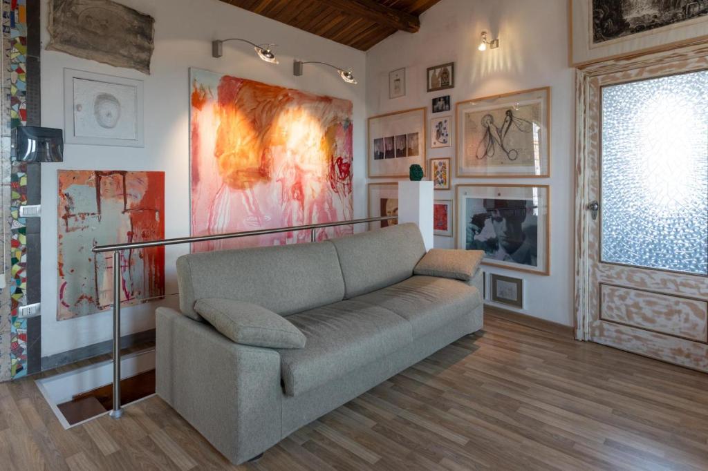 ein Wohnzimmer mit einem Sofa und Gemälden an der Wand in der Unterkunft La dimora degli artisti in Torre Alfina