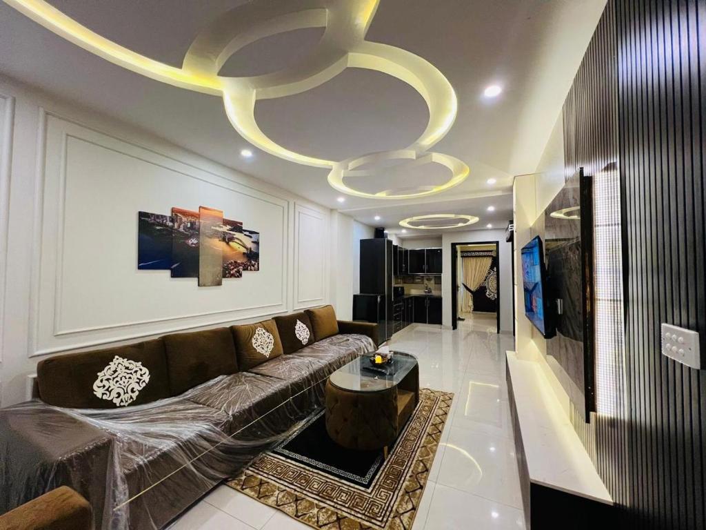 sala de estar con sofá y lámpara de araña en Luxury 1-Bed Apartment Bahria en Lahore