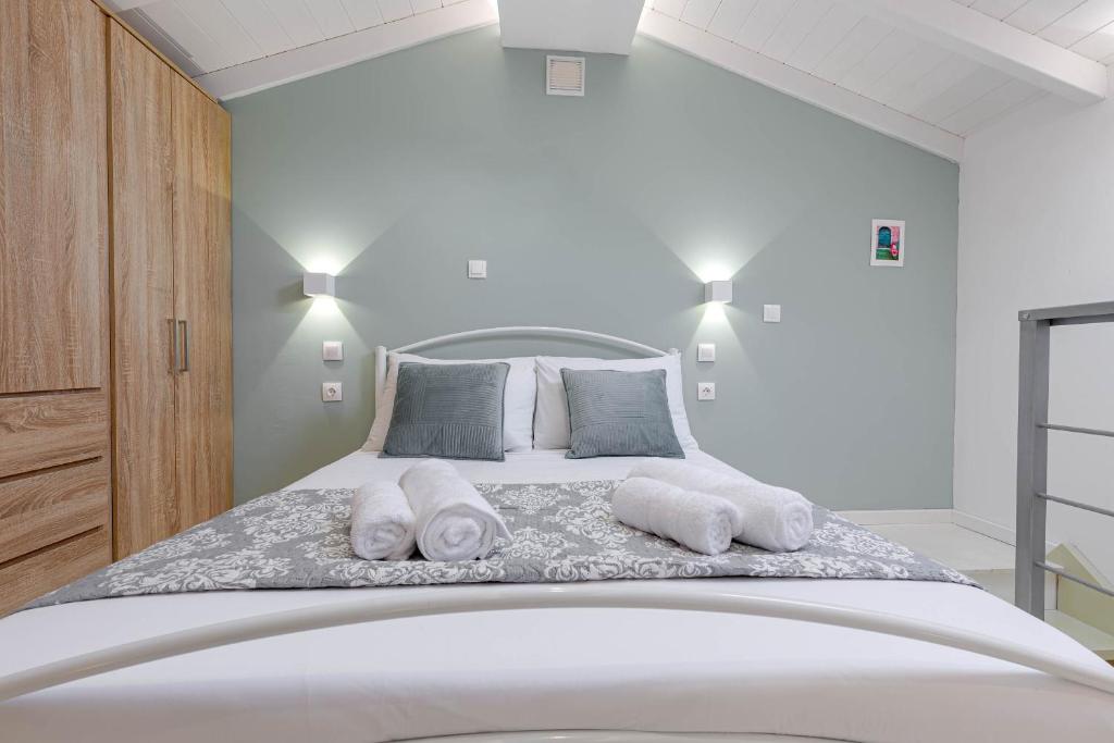 Un dormitorio blanco con una cama con toallas. en Viatzo Loft Apartment en Potamós