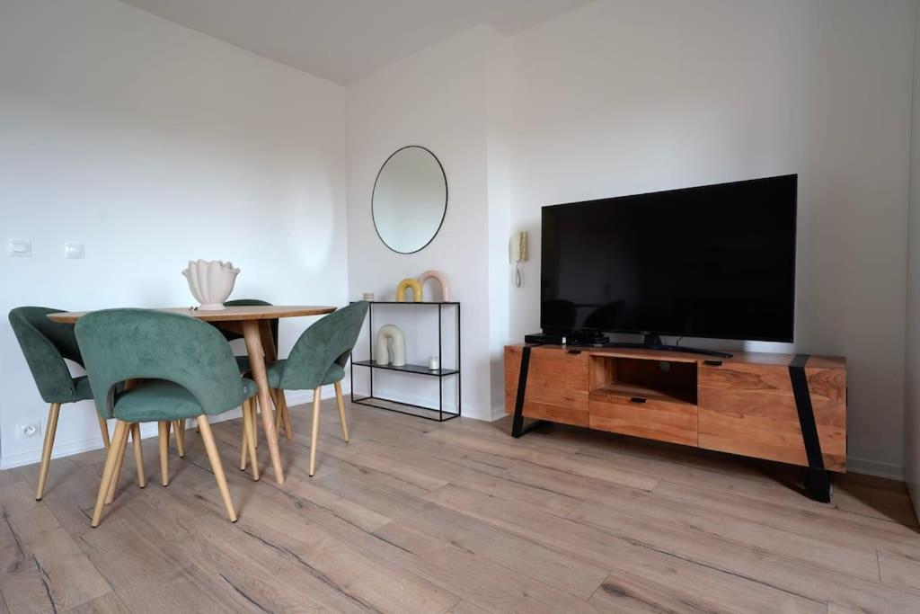 un salon avec une télévision, une table et des chaises dans l'établissement Le Douillet - Aux portes de Paris - 323B, à Rueil-Malmaison