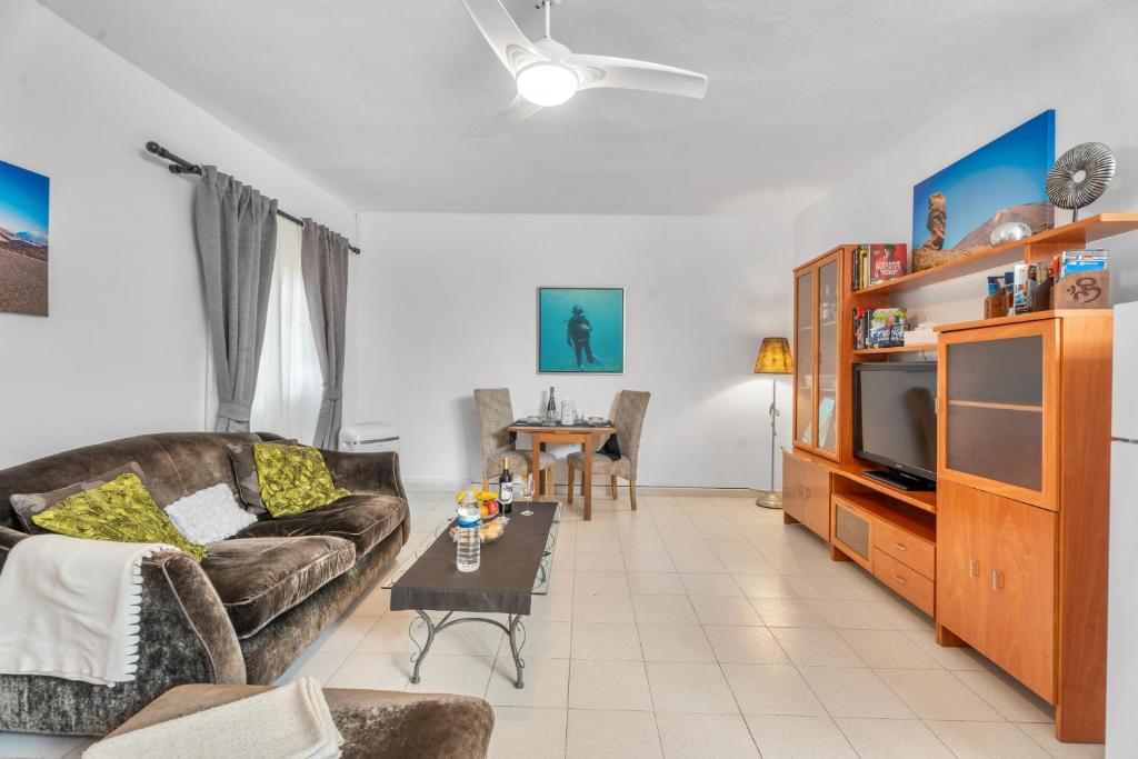 a living room with a couch and a tv at Bonito Apartamento en Tenerife Sur in Guía de Isora