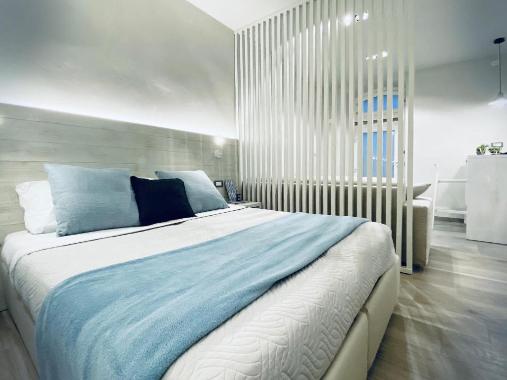 a bedroom with a large bed with blue pillows at Appartamento - Angolo di Rio in Riomaggiore