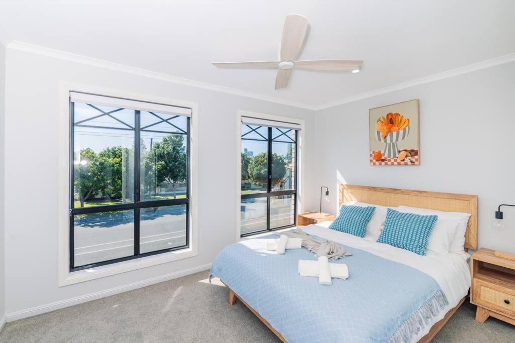 a bedroom with a bed and a ceiling fan at KozyGuru Gold Coast Broadbeach Holiday Home in Gold Coast