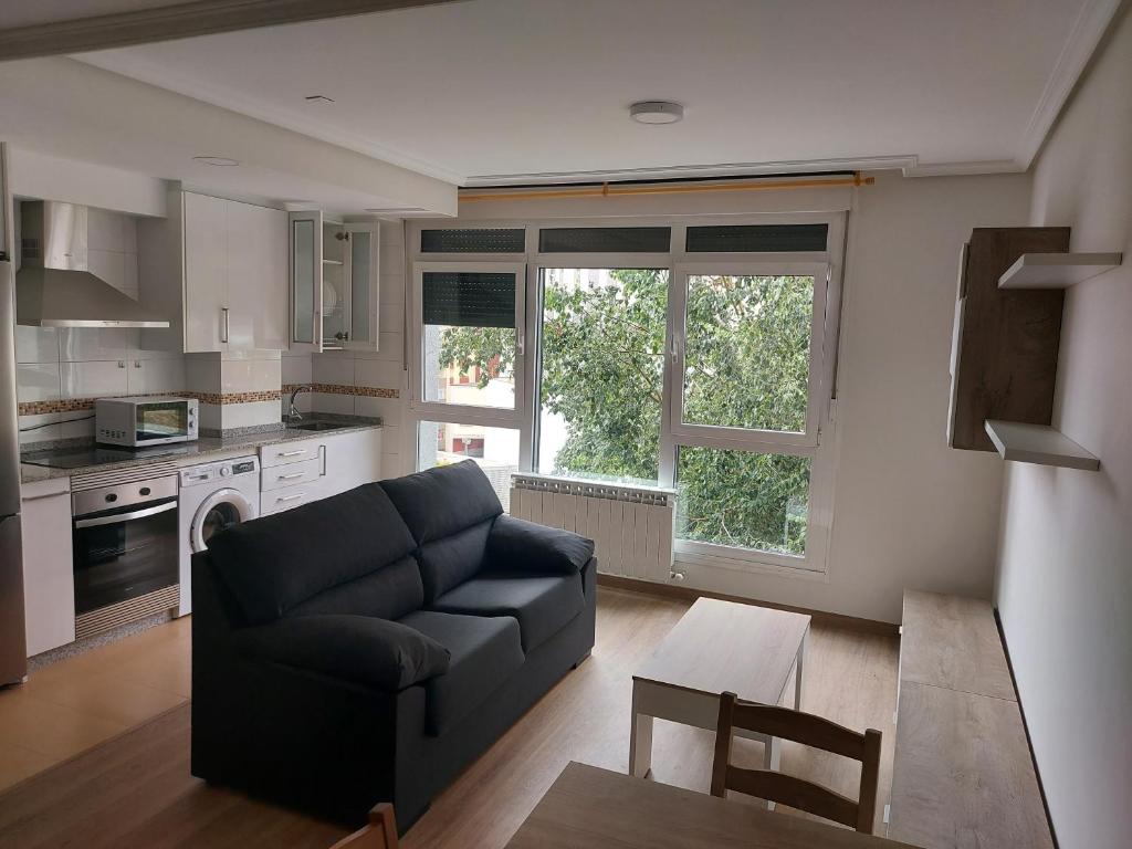 een woonkamer met een bank en een keuken bij Apartamentos Manolo in Lugo