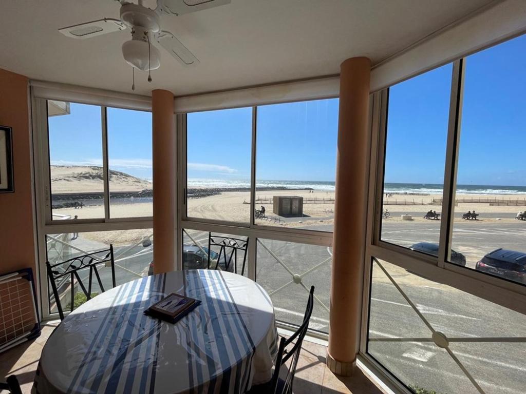 a table and chairs in a room with a view of the beach at Appartement Vieux-Boucau-les-Bains, 2 pièces, 5 personnes - FR-1-379-38 in Vieux-Boucau-les-Bains