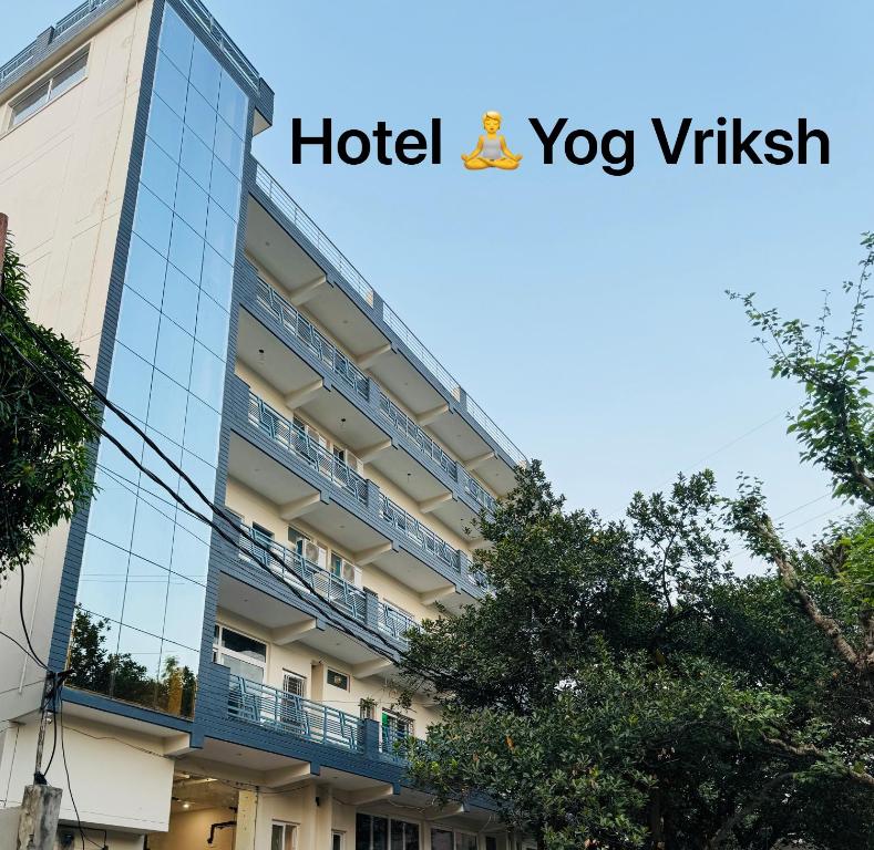 a hotel with a sign on the side of a building at Hotel Yog Vriksh in Rishīkesh