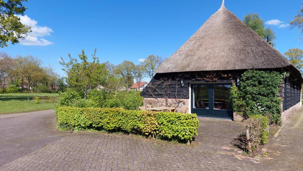 un pequeño edificio de piedra con techo de hierba en Havelterhoeve en Havelte