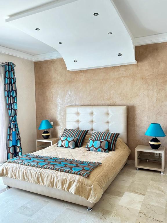 Fabulous Apartment in Marina Agadir في أغادير: غرفة نوم مع سرير كبير مع مصابيح زرقاء