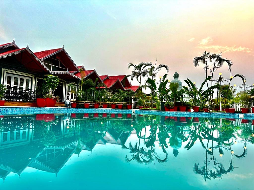 a swimming pool in front of a resort at YKC FARMS in Bāghdogra
