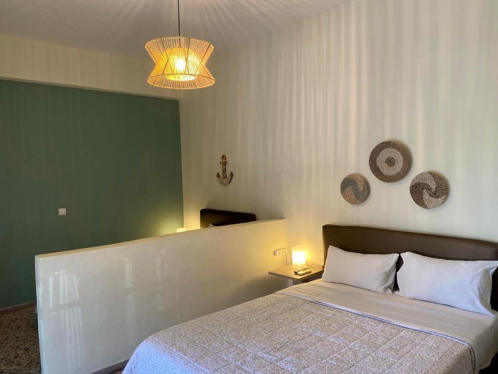 a bedroom with a bed and a chandelier at Galazia Nera Apartments in Agios Andreas
