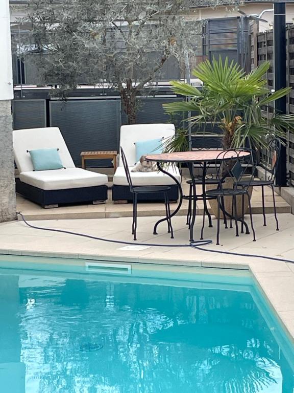 d'une terrasse avec une table et des chaises à côté de la piscine. dans l'établissement Appartement jerry et joy, à Wolfisheim