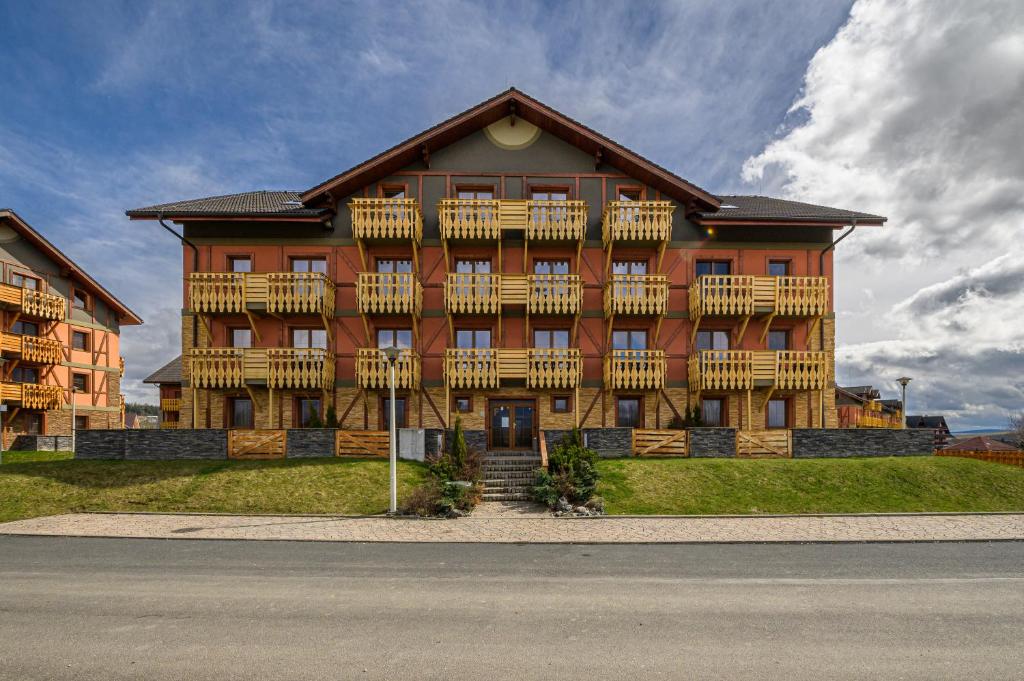 a large building with balconies on the side of a street at Tatragolf Mountain Resort F208 in Veľká Lomnica