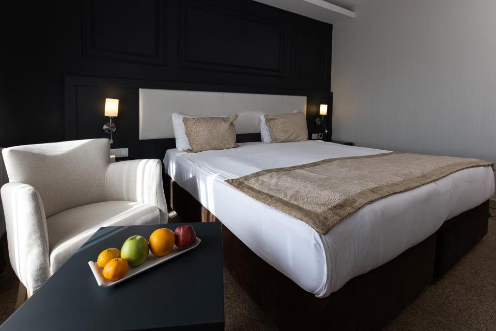 Habitación de hotel con cama y bandeja de fruta en una mesa. en Bonjur Hotel Thermal & Wellness Club en Ankara