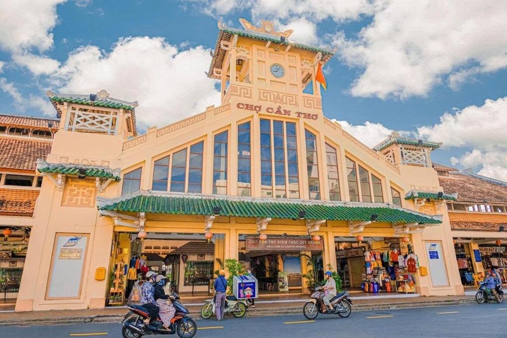 a group of people riding motorcycles in front of a building at Nam Đô Hotel Cần Thơ Downtown in Can Tho