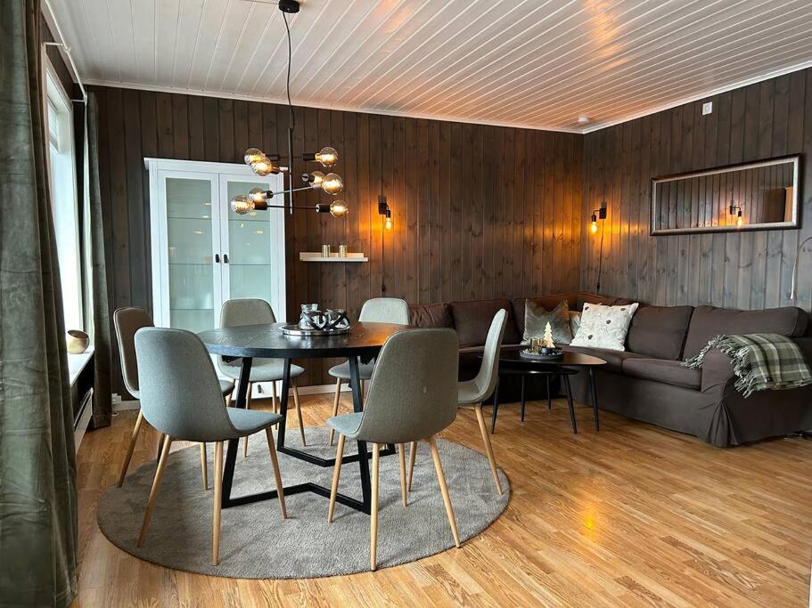 a dining room with a table and chairs and a couch at Leilighet Ski in/out, golf in Vradal