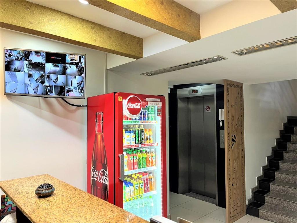 um frigorífico de coca cola num quarto com escadas em DINH DINH 2 AIRPORT HOTEL em Cidade de Ho Chi Minh