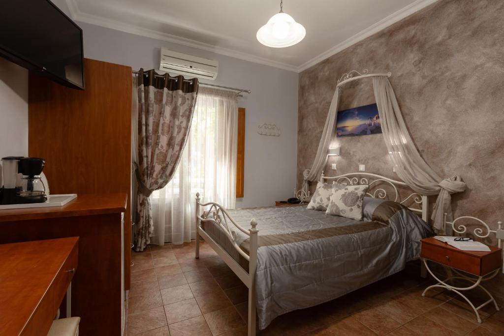 A bed or beds in a room at Polydefkis Hotel