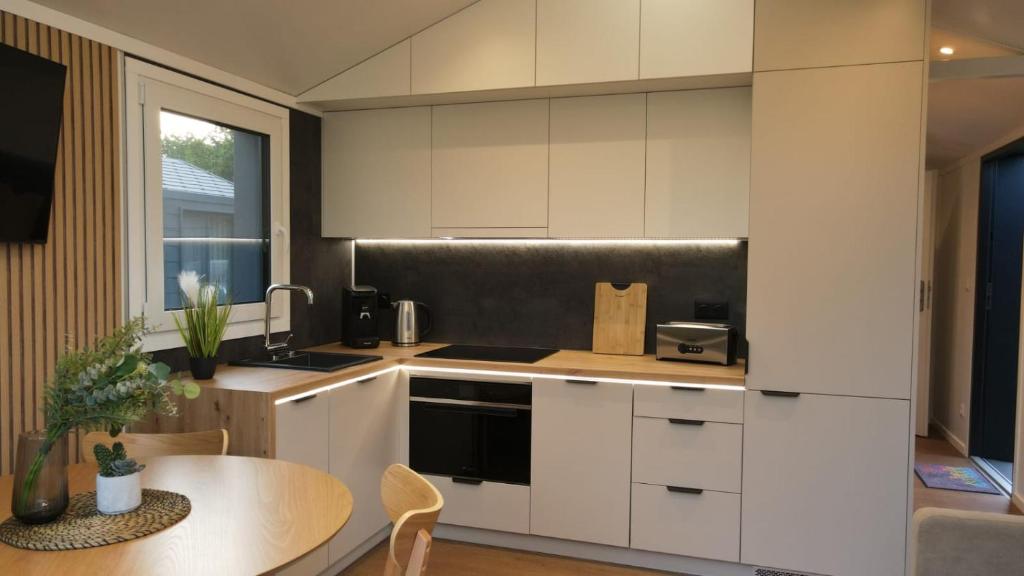 uma cozinha com armários brancos e uma mesa em LandZeit - get your tiny moments em Sohren