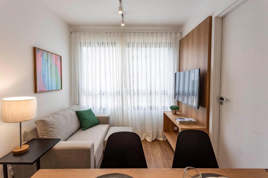 a living room with a couch and a table at Boulevard Ibirapuera in São Paulo