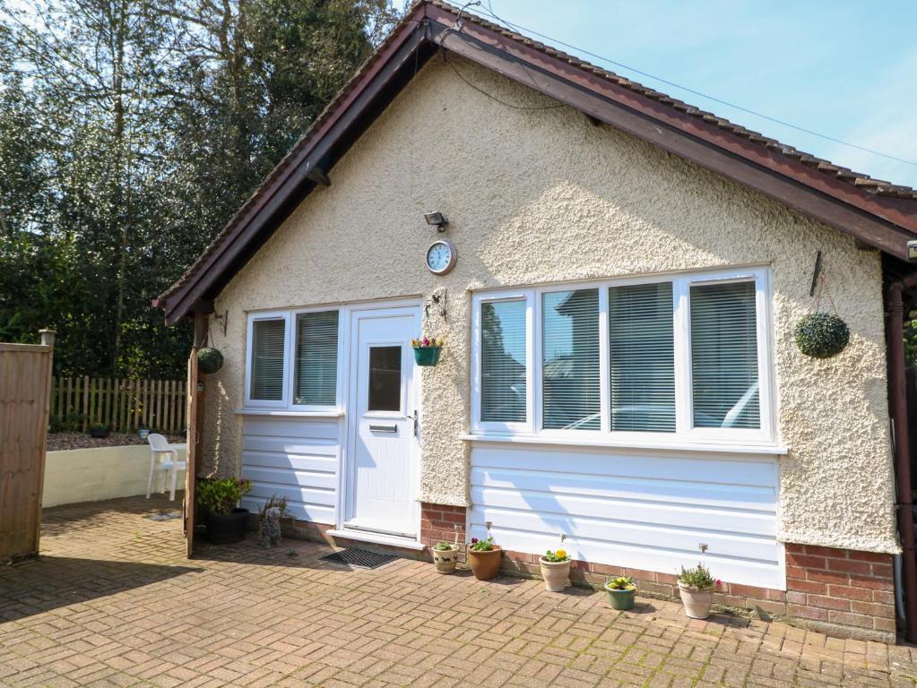 een garage met een witte deur en potplanten bij Paws-A-While in Norwich