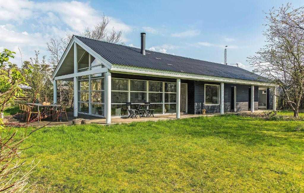a house with a large screened in porch with a picnic table at 4 Bedroom Pet Friendly Home In Strandby in Strandby