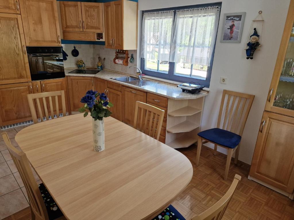 a kitchen with a table with a vase of flowers on it at Apartment Luka at Soča & Koritnica confluence in Bovec