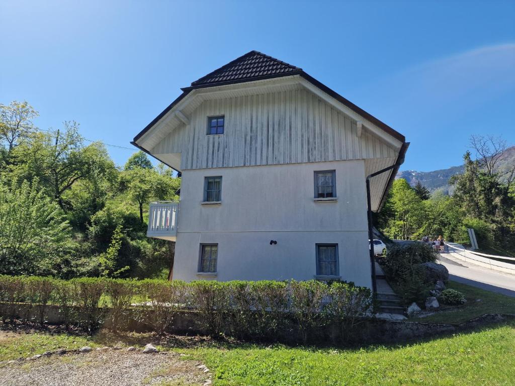 a large white building with a gambrel roof at Apartment Luka at Soča & Koritnica confluence in Bovec