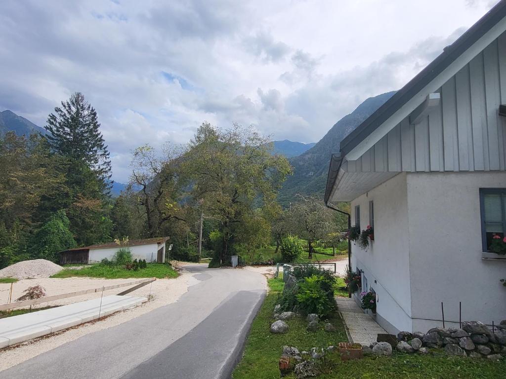 a road next to a white building with a mountain at Apartment Luka at Soča & Koritnica confluence in Bovec