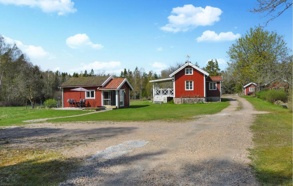 a dirt road leading to two red homes at Cozy Home In Henn With Kitchen in Henån