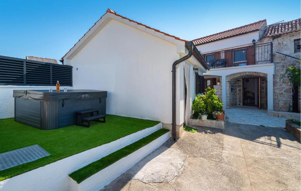 a white house with a yard with grass and a building at Lovely Home In Slivnica With Wifi in Slivnica