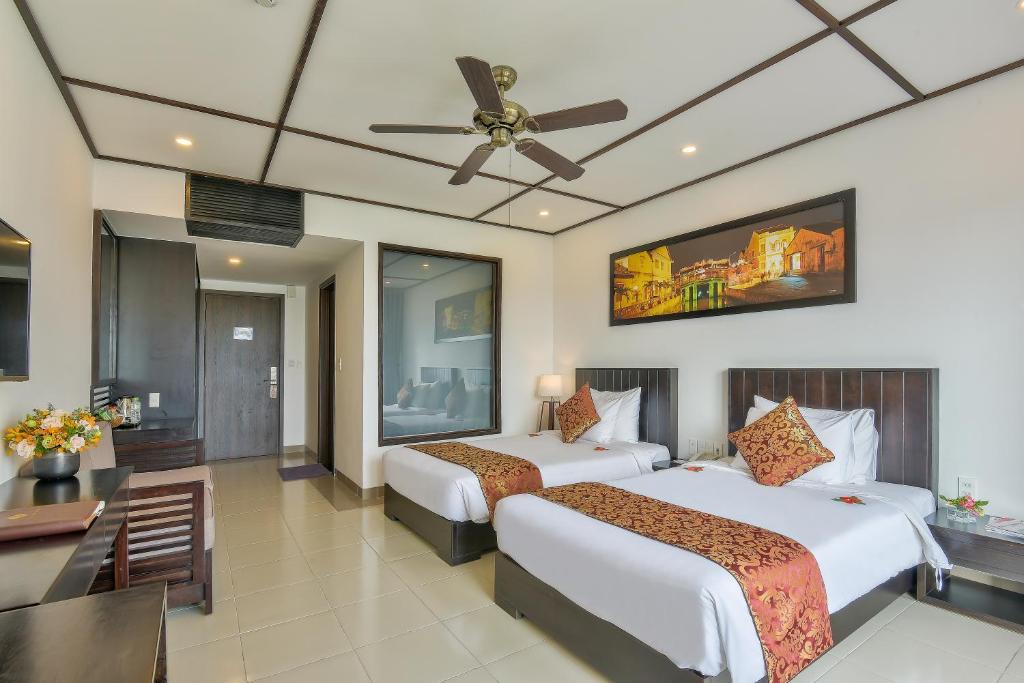 Postel nebo postele na pokoji v ubytování White Lotus Hotel Hoian