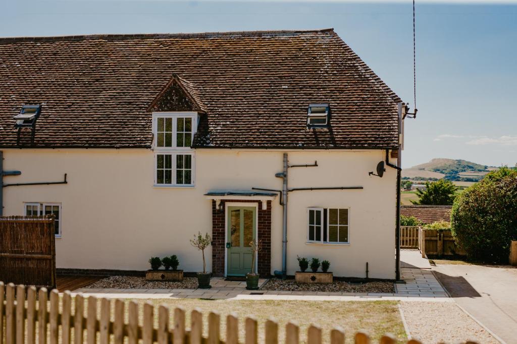 una casa bianca con una recinzione di fronte di Dairyman's Cottage At Tapnell Farm a Yarmouth