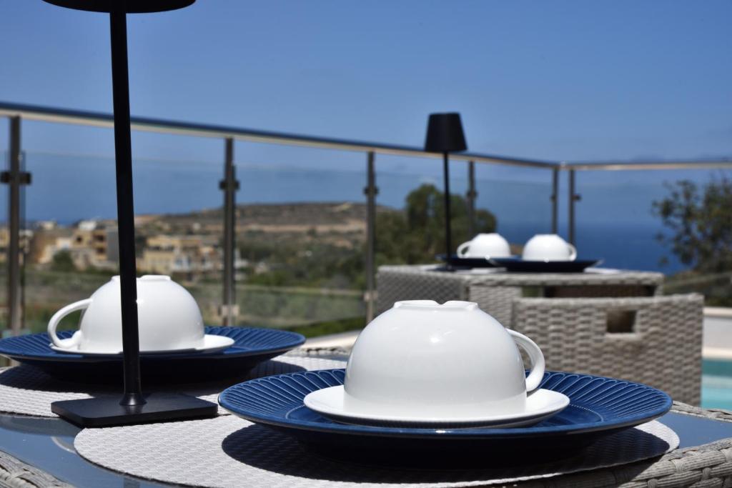 a table with two white tea pots and plates on it at San Pawl bnb farmhouse CALYPSO in Xagħra