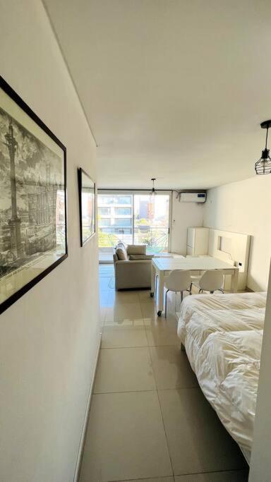 a bedroom with a bed and a table in a room at Luminoso departamento en Castelar centro p/2 pers in Castelar