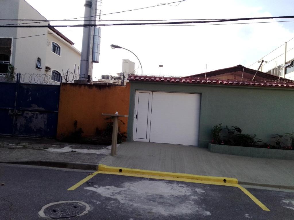 un garage avec une porte blanche dans un parking dans l'établissement Home Enseada Beach, à Guarujá
