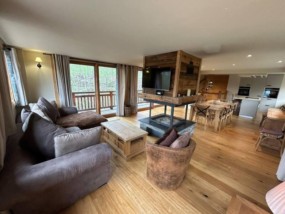 una sala de estar con un sofá y una mesa en Chalet Rose, en Morzine