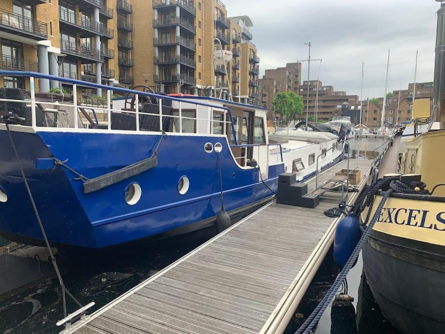 a blue boat is docked at a dock at Historic Dutch Barge, Idyllic location in London
